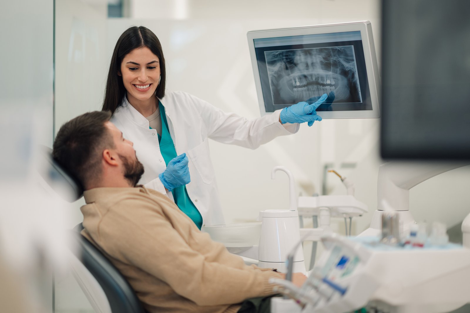 dentist showing teeth x ray to patient in modern clinic